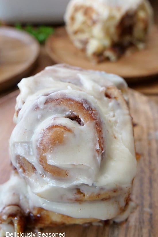 A close up of a iced cinnamon roll.