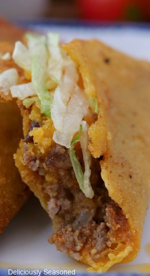 A close up of a fried taco with a few bites taken out of it.