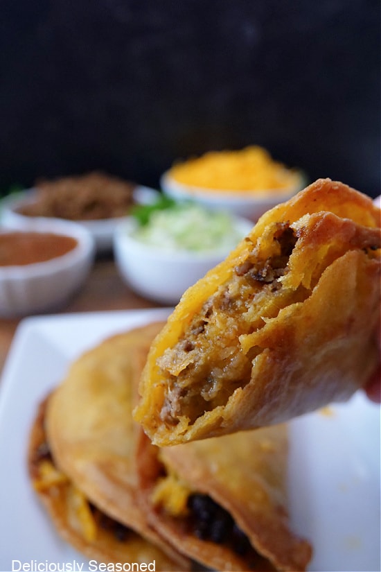 A close up photo of a crispy taco with a bite taken out of it.