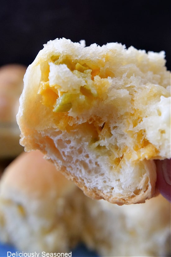 A close up of a jalapeno cheese roll with a bite taken out of it.