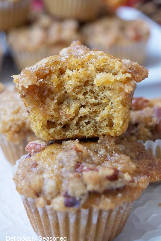 A close up of mini butternut squash muffins with a bite taken out on one.
