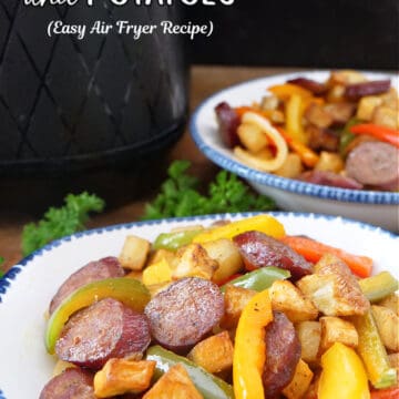 Two white bowls with blue trim filled with a serving of sausage, peppers and potatoes.