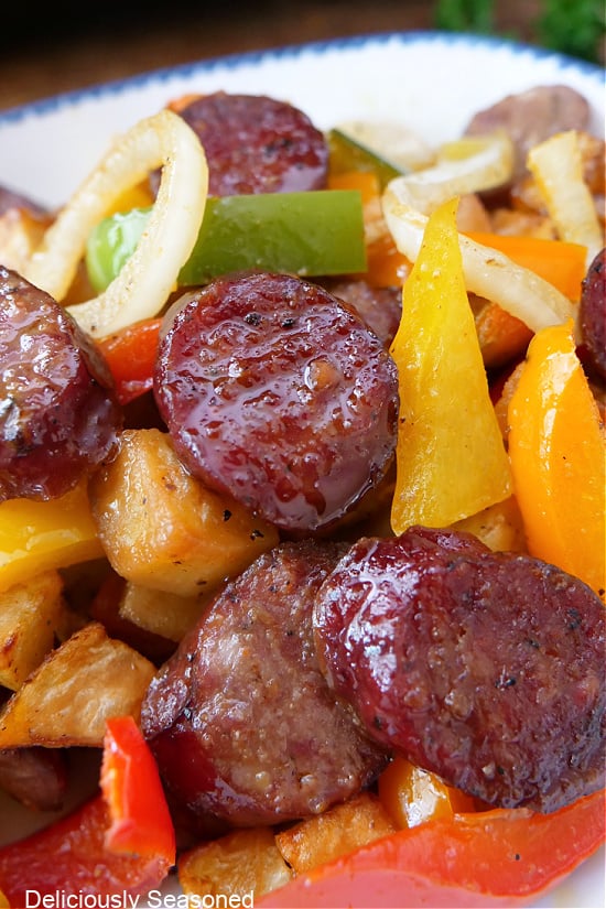 A close up photo of air fryer sausage, peppers and potatoes.