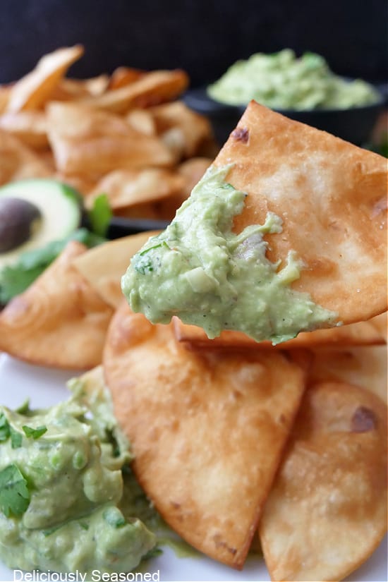 A close up of homemade fried flour tortilla chips that was dipped in homemade guacamole.