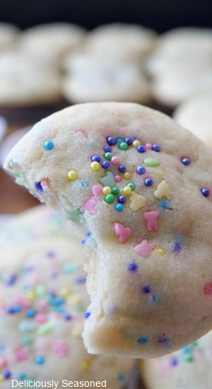 A close up of a sugar cookie with a bite taken out of it.