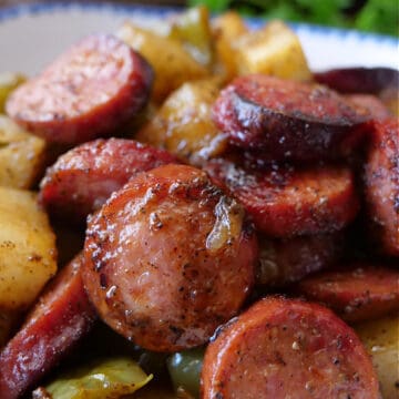 A close up of sliced sausage and potatoes.