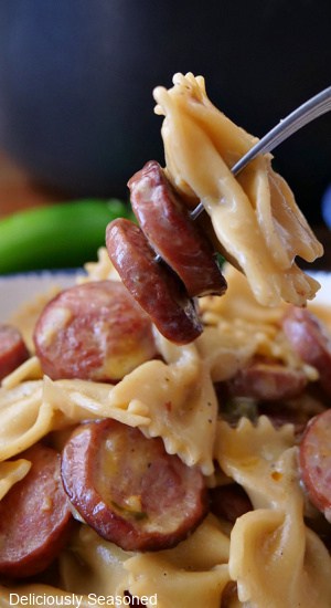 A forkful of smoked sausage and bow tie pasta.