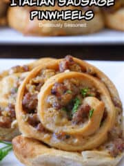 A close up of an Italian sausage pinwheel on a white plate.