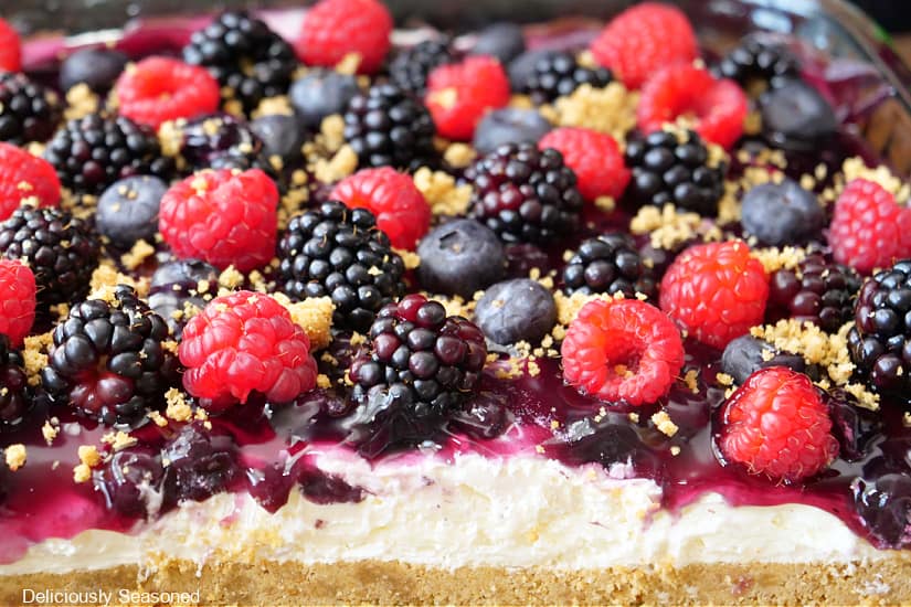A horizontal photo of mixed berry dessert with fresh berries on top.
