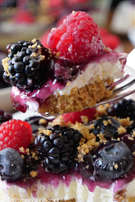 A close up of a bite of mixed berry dessert on a fork.