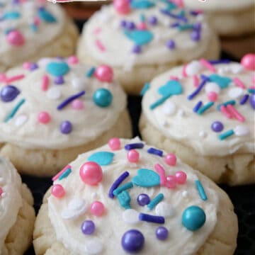 Mini sugar cookies with white frosting and candy sprinkles on top.