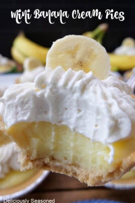 A close up of a mini banana cream pie with a big bite taken out of it.