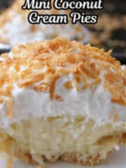 A close up of a mini coconut cream pie with a bite taken out of it showing the custard filling, the whipped cream topping, and shredded toasted coconut.