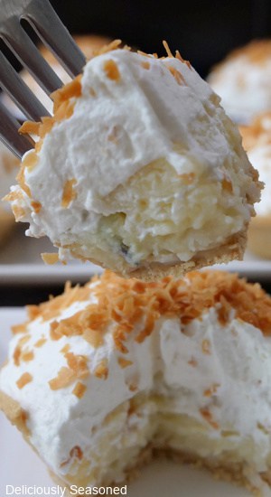 A close up of a bite of coconut cream pie on a fork.