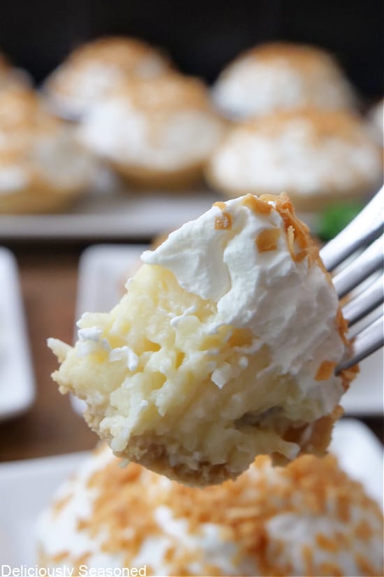 A close up of a bite of coconut cream pie on a fork.