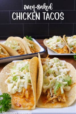 A wood surface with three white plate with baked chicken tacos on them.