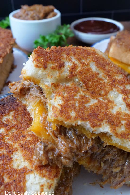 A close up of a grilled cheese sandwich with a bite taken out of one half.