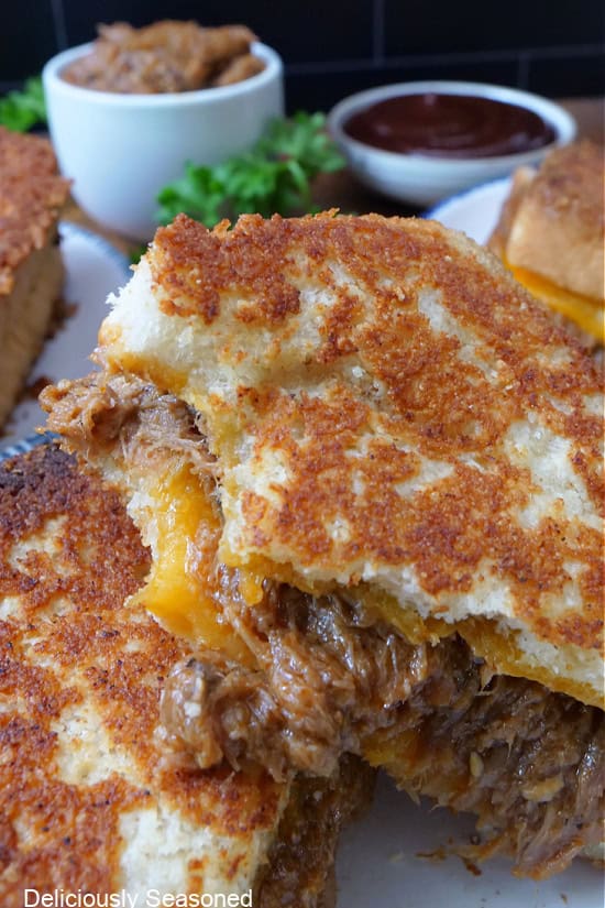 A grilled cheese sandwich with a bite taken out of one half.