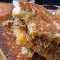A close up of a pulled pork grilled cheese sandwich.