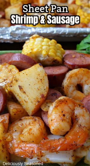 A photo of shrimp, potatoes sausage and corn.