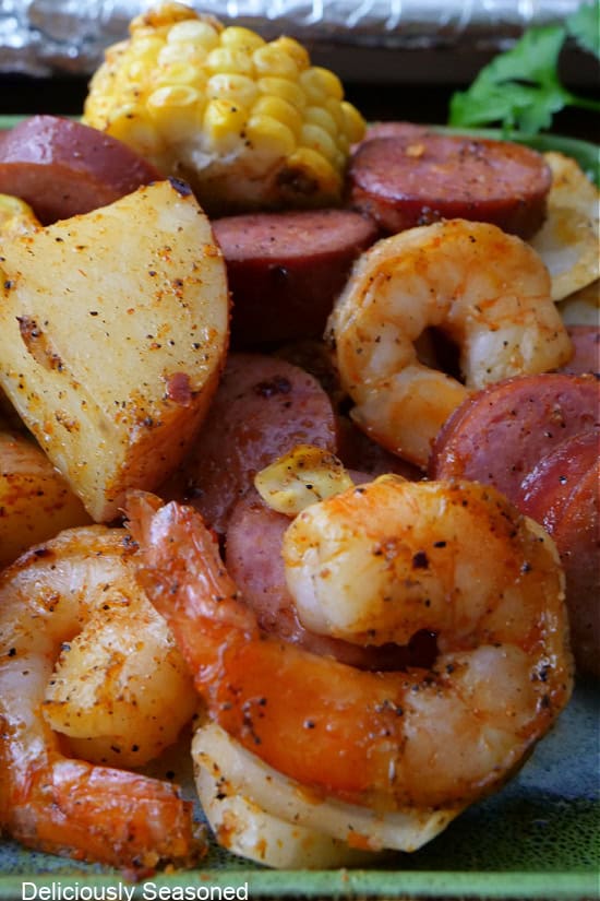 A close up of shrimp, potatoes, sausage, and corn.