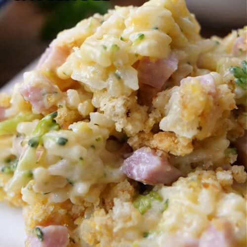 A serving of cheesy ham broccoli rice casserole on a white plate with the title at the top of the photo.