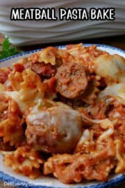 A serving of meatball pasta bake in a white bowl with blue trim.