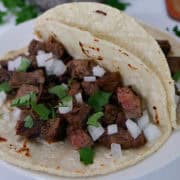 Two tacos on a white plate.