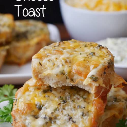 Three pieces of garlic cheese toast on a white plate with a bite taken out of the top slice of cheese bread.
