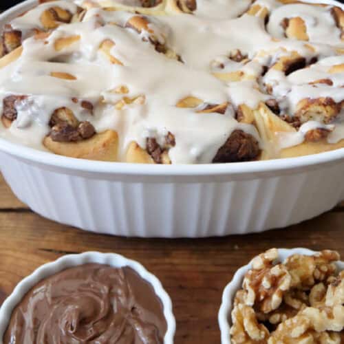 A white oval baking dish with nine Nutella cinnamon rolls in it.