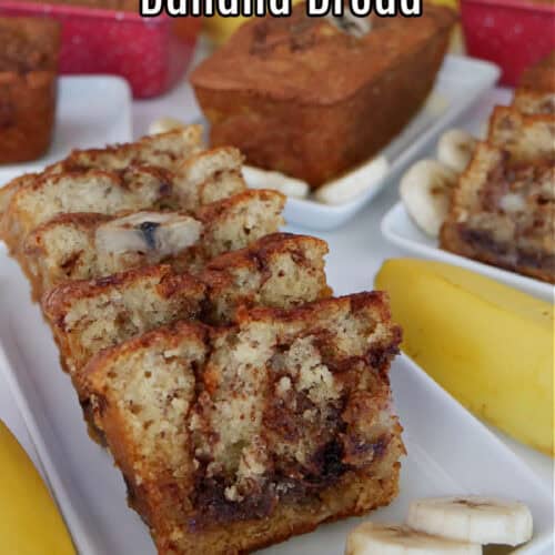 A white surface and white plates with mini loaves of banana bread on them.