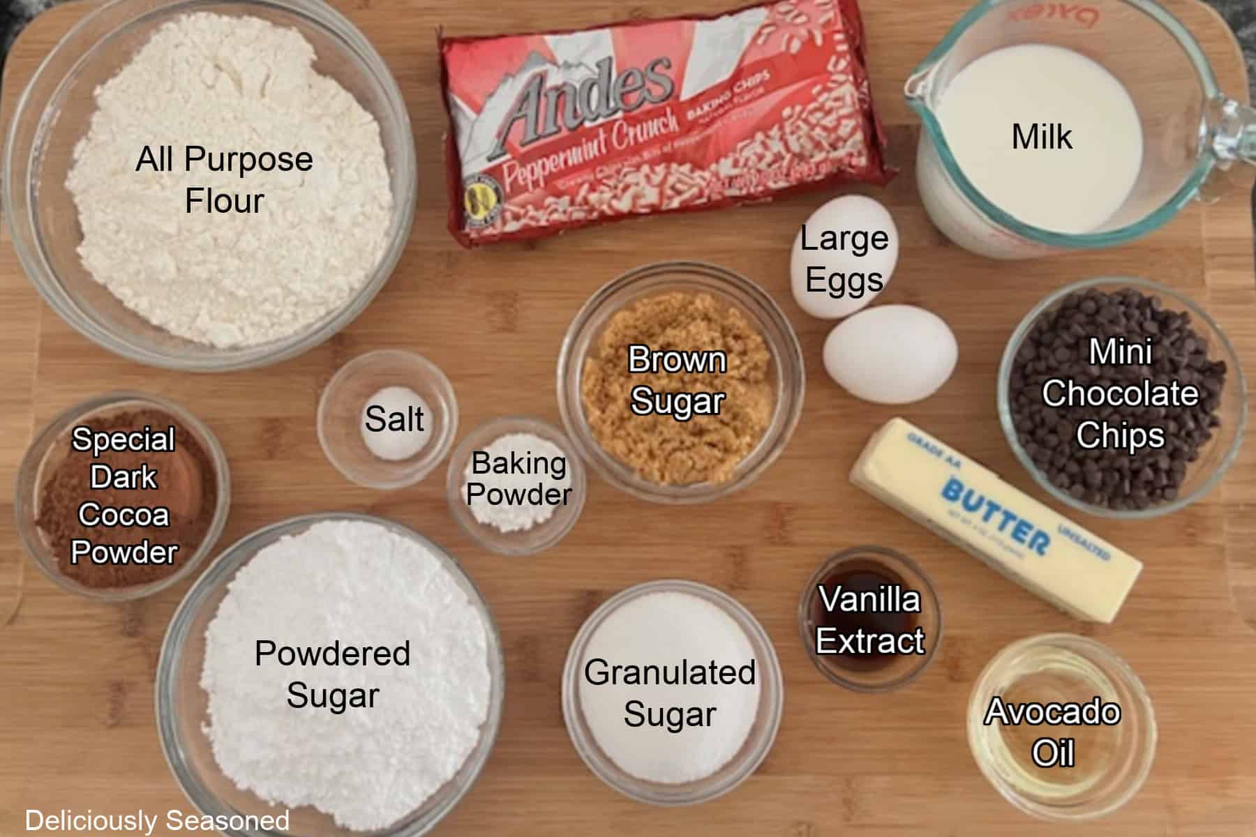 A wood surface with all the ingredients needed to make chocolate donuts on it.