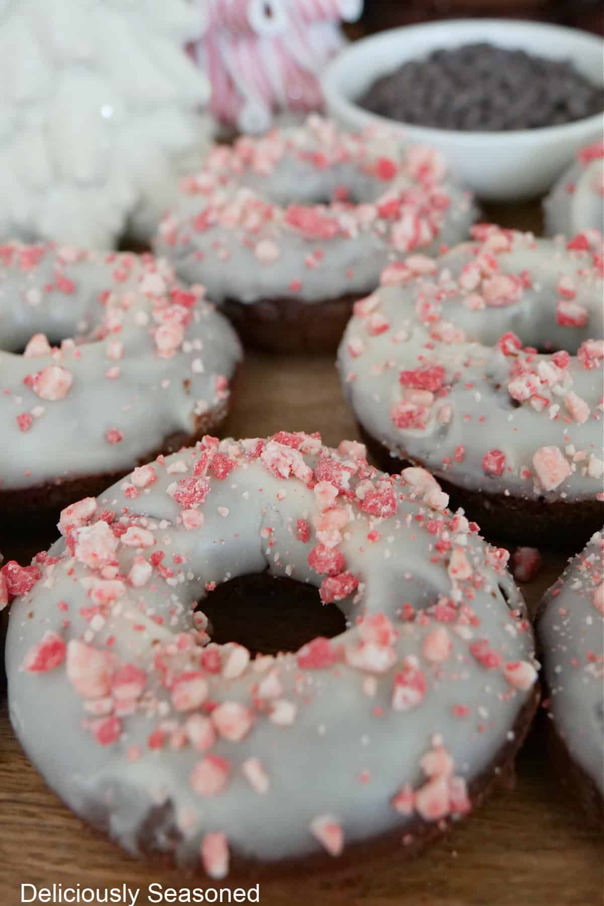 Iced chocolate donuts on a wood surface.