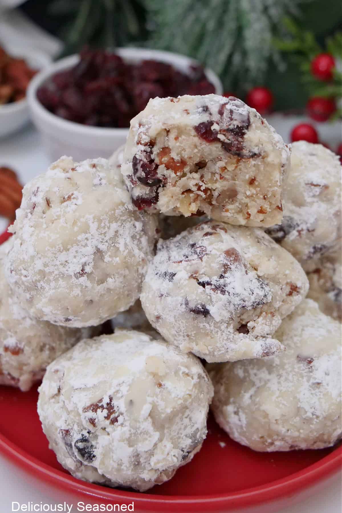 A stack of snowball cookies with a bite out of the one on top.