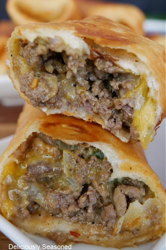 Two fried burrito halves stacked on top of each other showing the inside ingredients.