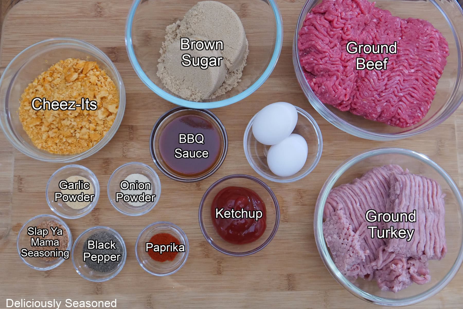 A wood surface with all the ingredients on it to make mini brown sugar meatloaves.