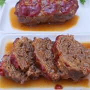 A white surface with two mini meatloaves on it and one is sliced into bite-size pieces.