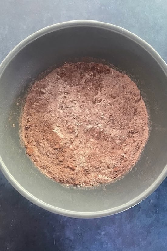 A grey mixing bowl with dry cookie ingredients in it.