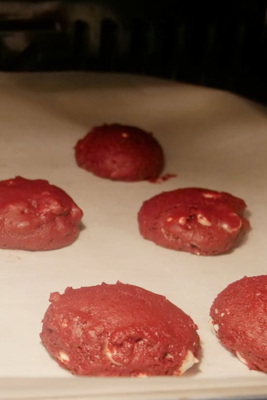 A baking sheet with cookies baking on it in the oven.