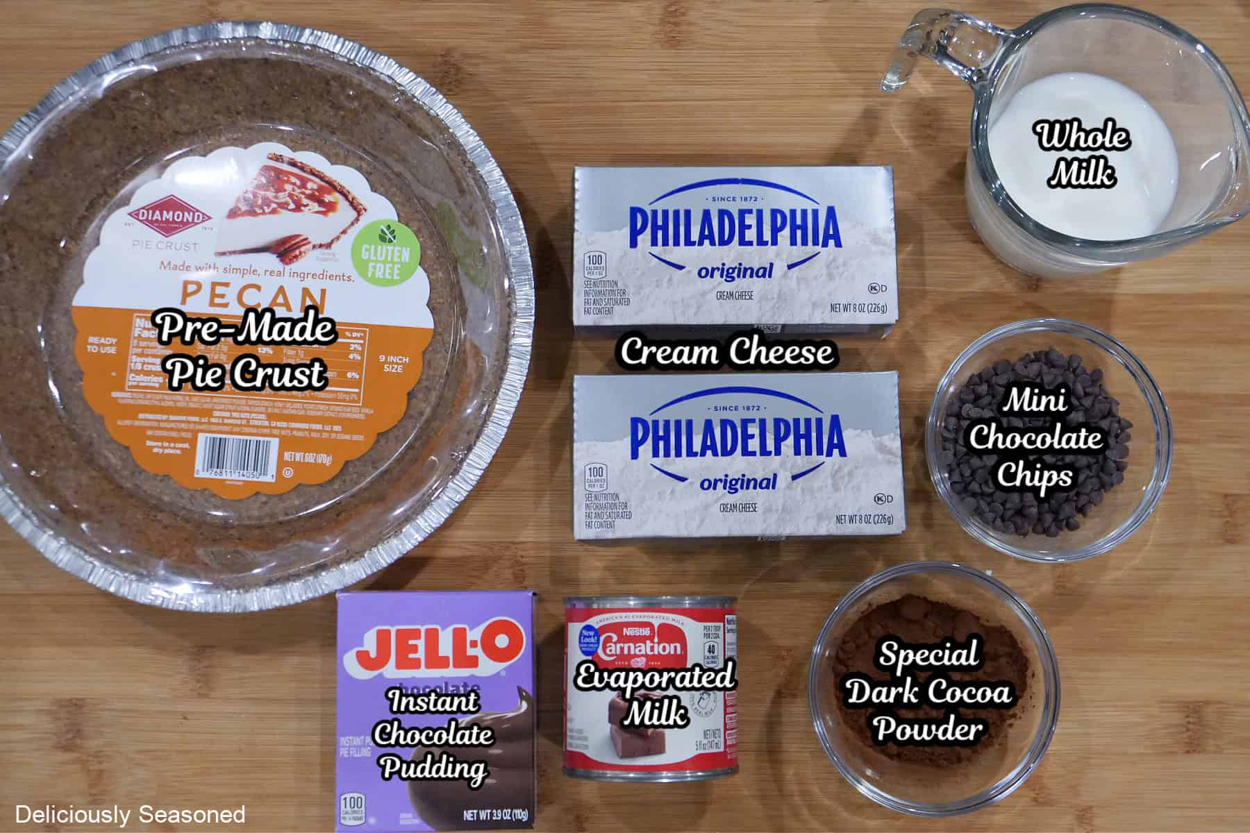 A wood surface with the ingredients to make chocolate cream pie placed on it.