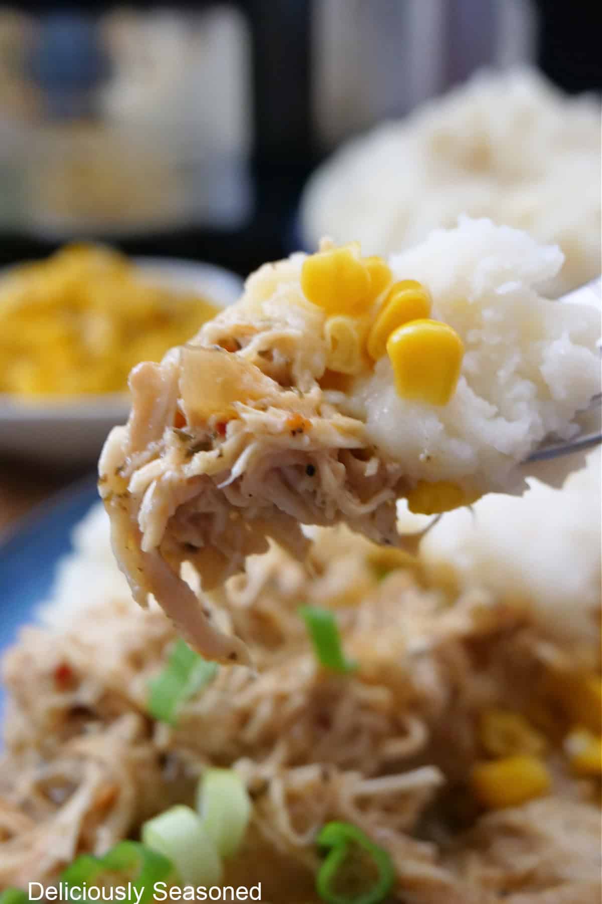 A bite of crock pot garlic parmesan chicken on a fork.