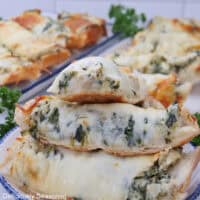 Slices of cheese bread filled with spinach artichoke dip inside.