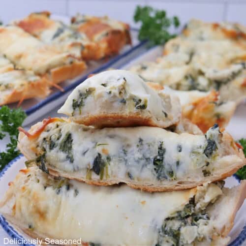 Slices of cheese bread filled with spinach artichoke dip inside.