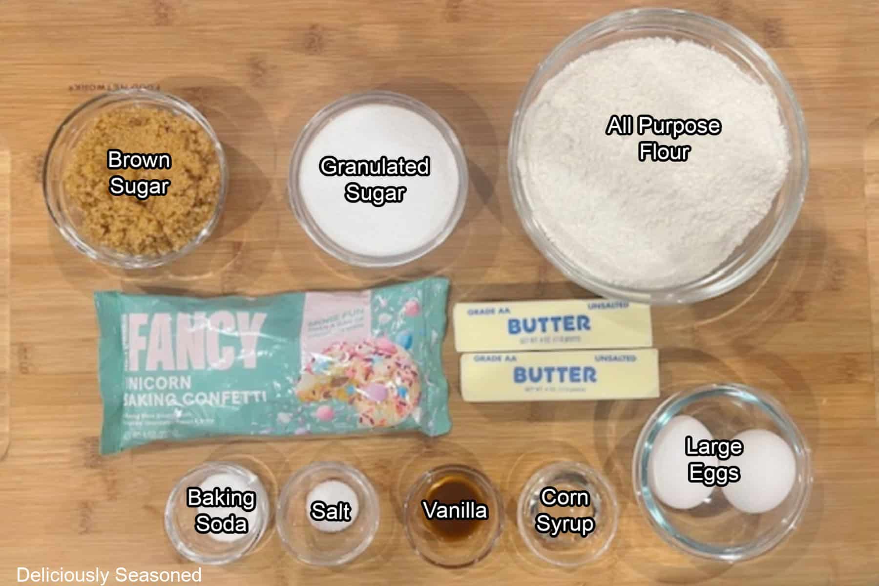 A wood surface with all the ingredients to make spring cookies on it.
