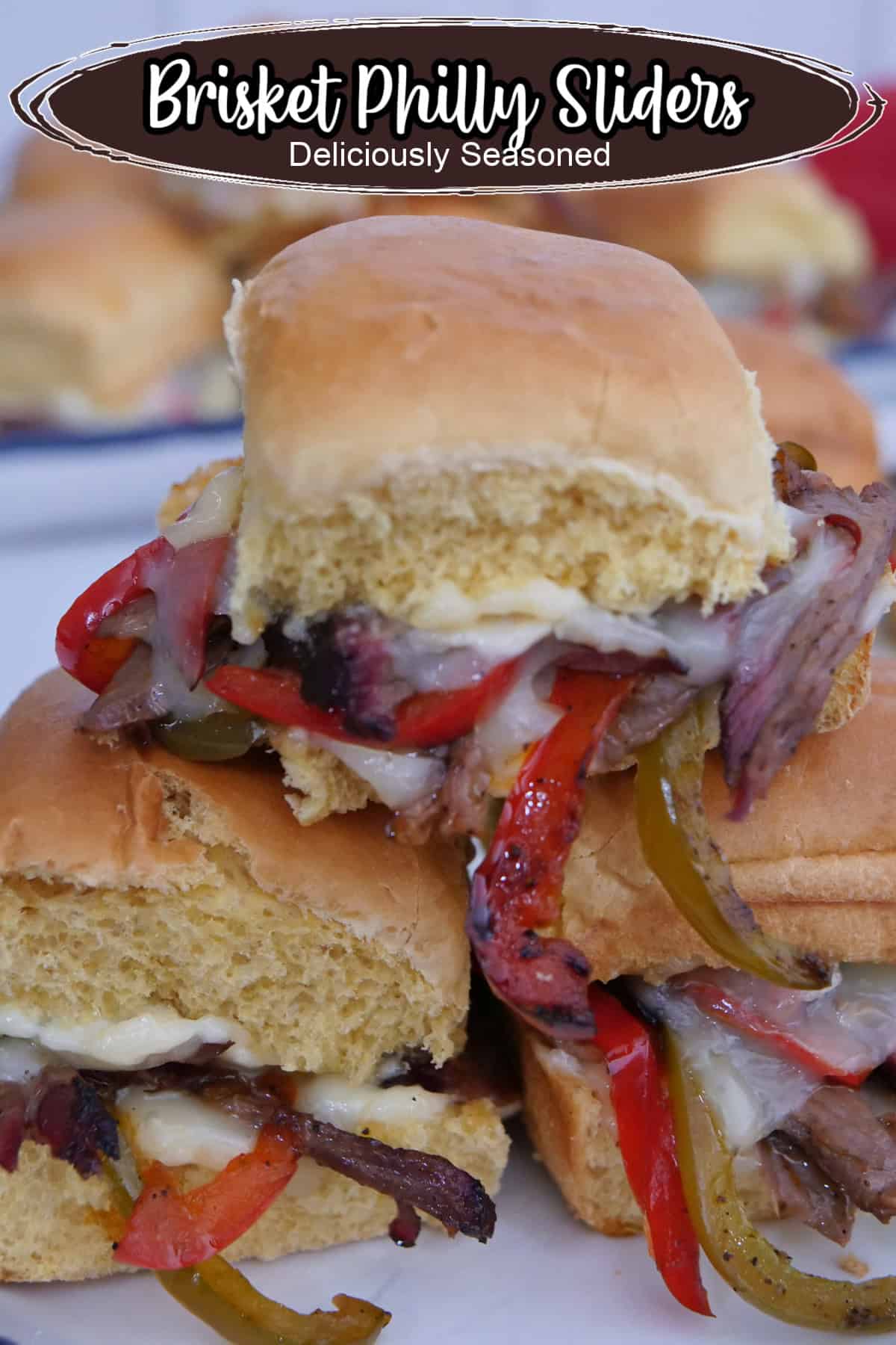 A white plate with blue trim with three brisket philly sliders on it.