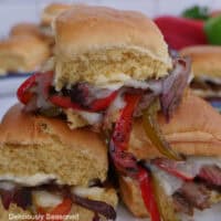 Three brisket philly sliders on a white plate.