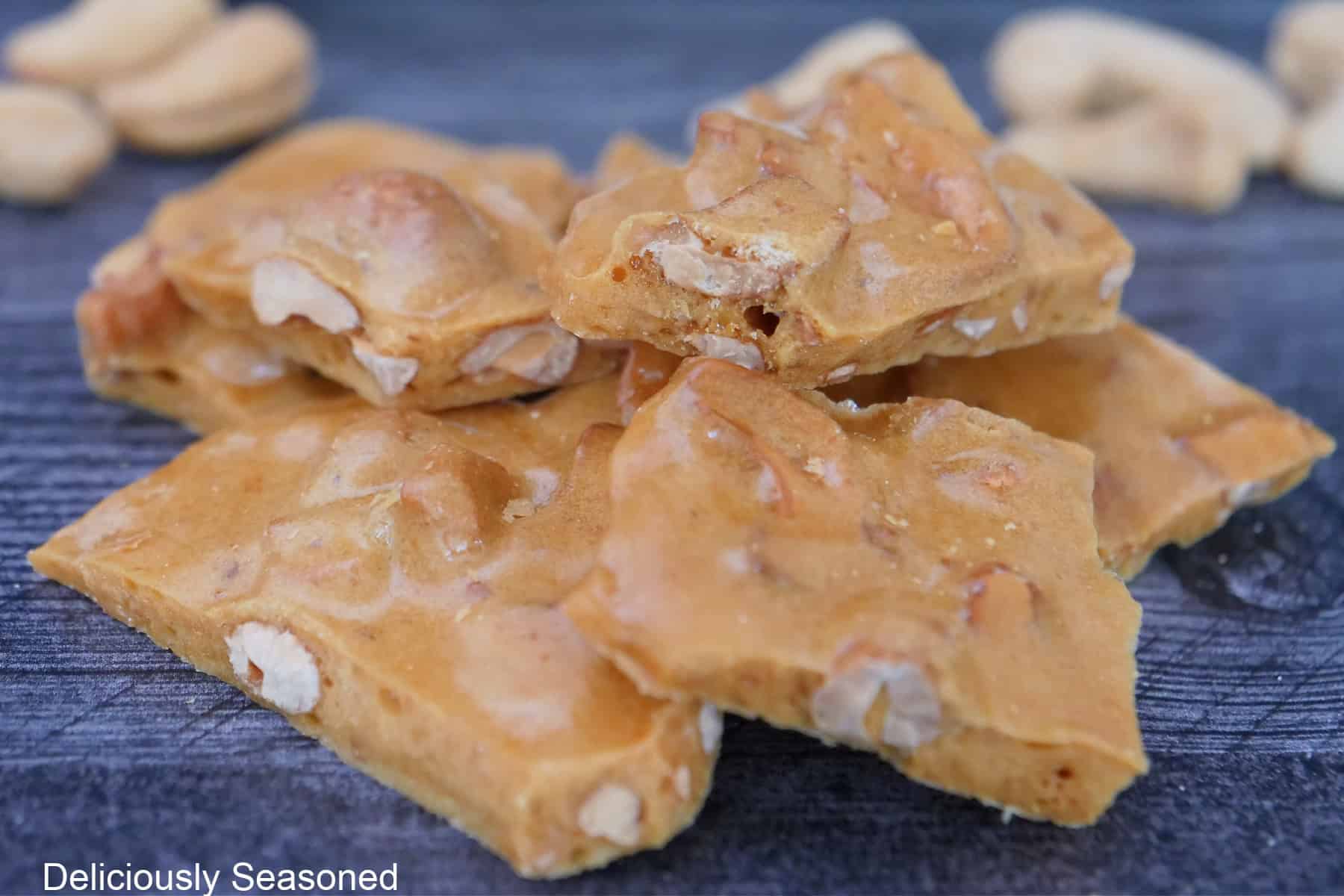 A blue surface with a small stack of cashew brittle on it.