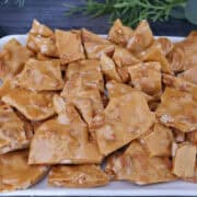 Homemade cashew brittle on a white plate.