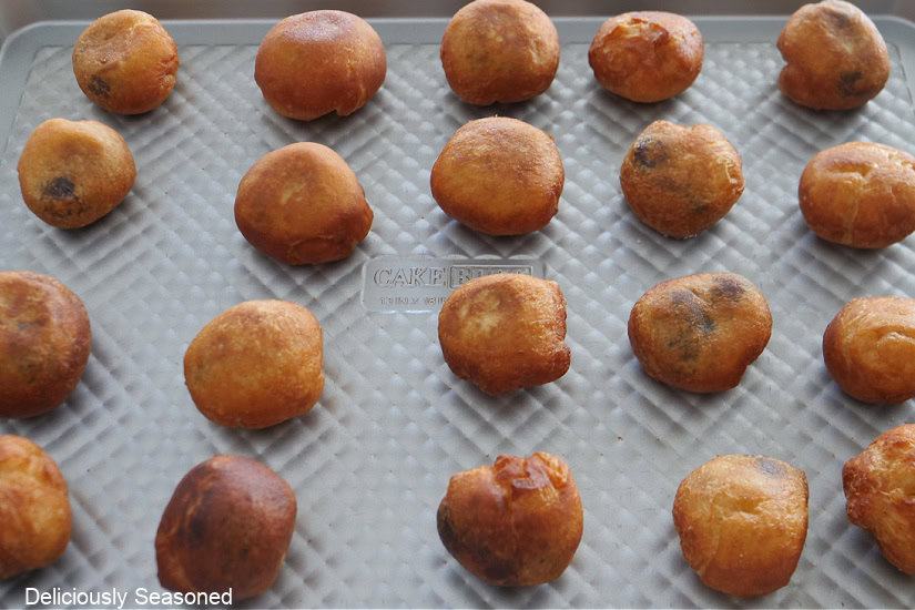 A silver baking sheet with 20 little cherry pie bombs on it after being flash fried.