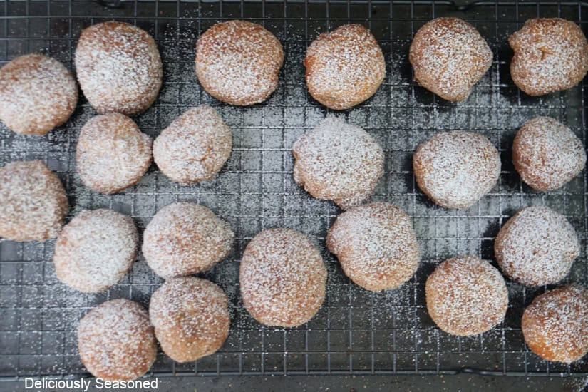 A baking sheet with a wire rack on top with cherry pie bombs dusted with powdered sugar.